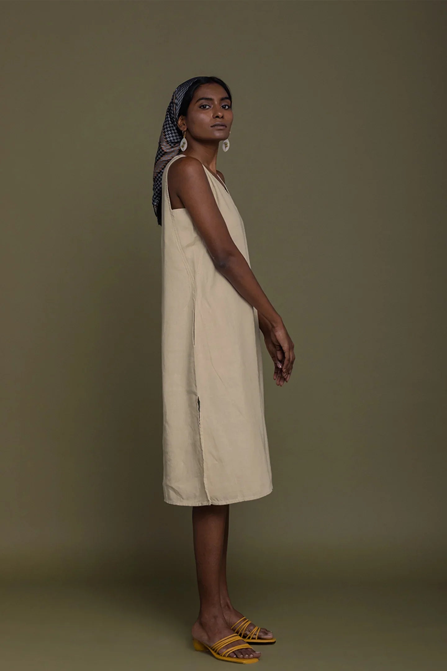 Side view of Reistor Reading Tea Leaves Dress in Neutral Beige, sleeveless V-neck midi dress for women.