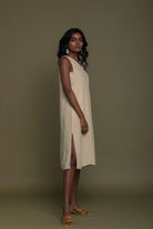 Side view of Reistor Reading Tea Leaves Dress in Neutral Beige, sleeveless V-neck midi dress with side slit.