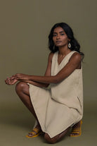 Reistor Reading Tea Leaves Dress in Neutral Beige, sleeveless V-neck midi dress shown in a seated pose.