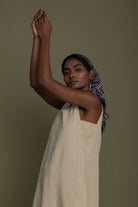 Woman wearing Reistor Reading Tea Leaves Dress in Neutral Beige, relaxed sleeveless midi dress in a portrait pose.