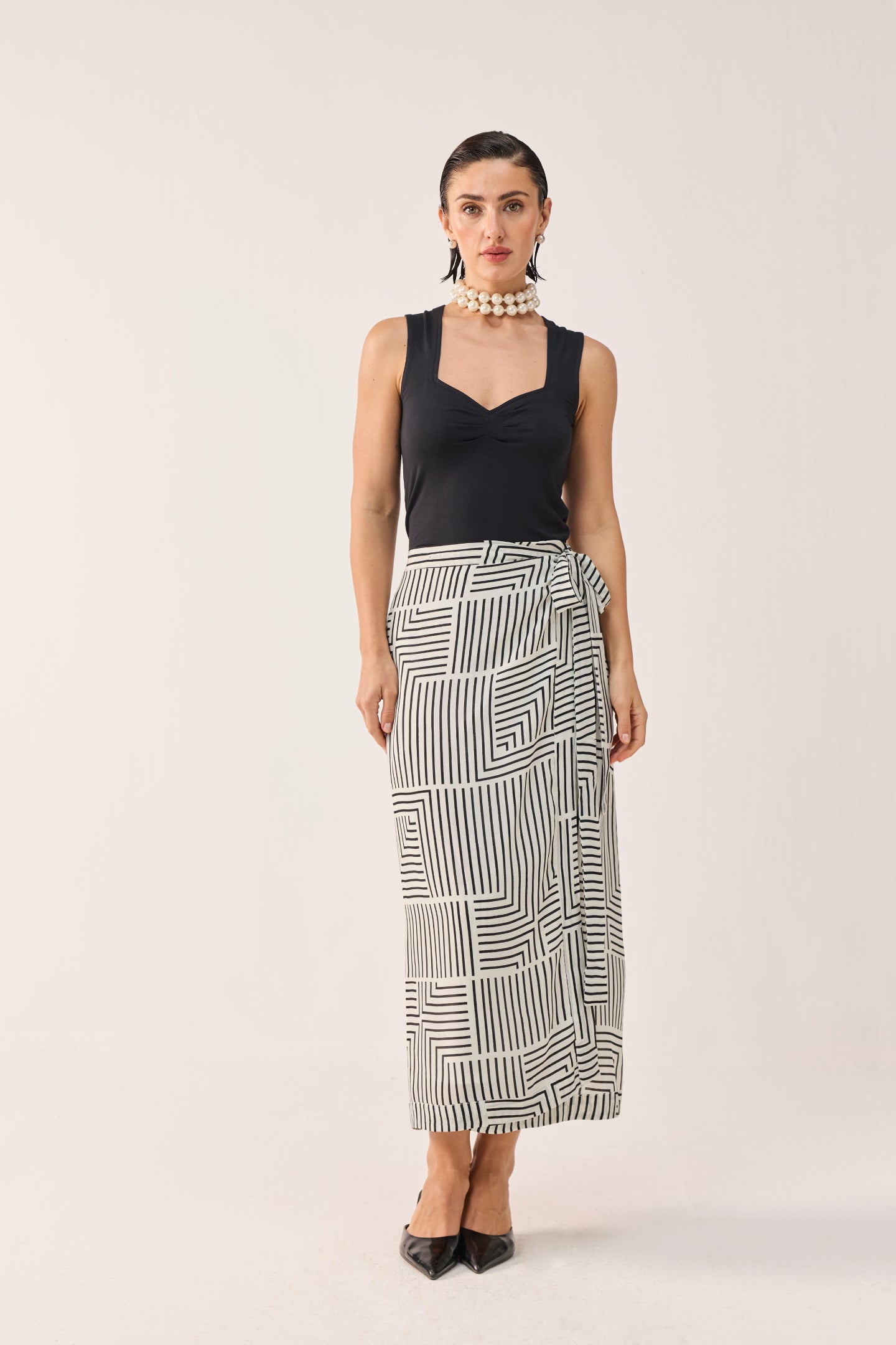 Reistor Regular Sweetheart Neck Top in Black styled with a monochrome geometric wrap skirt, offering a polished, modern look with timeless elegance.