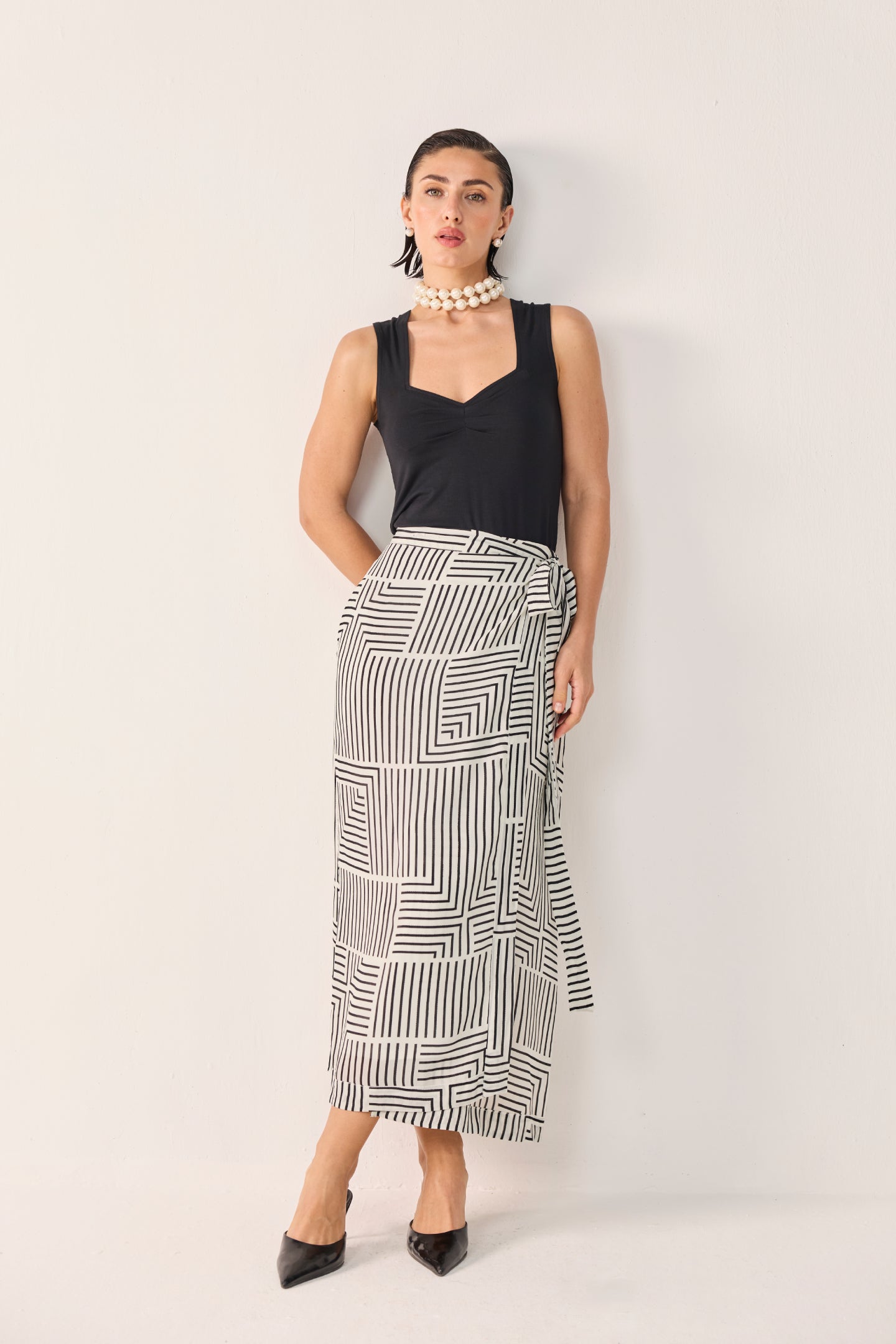 Reistor Regular Sweetheart Neck Top in Black paired with a striking geometric wrap skirt, delivering an elegant, contemporary silhouette for versatile styling.