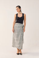 Model wearing Reistor Regular Sweetheart Neck Top in Black with a black and white printed wrap skirt.