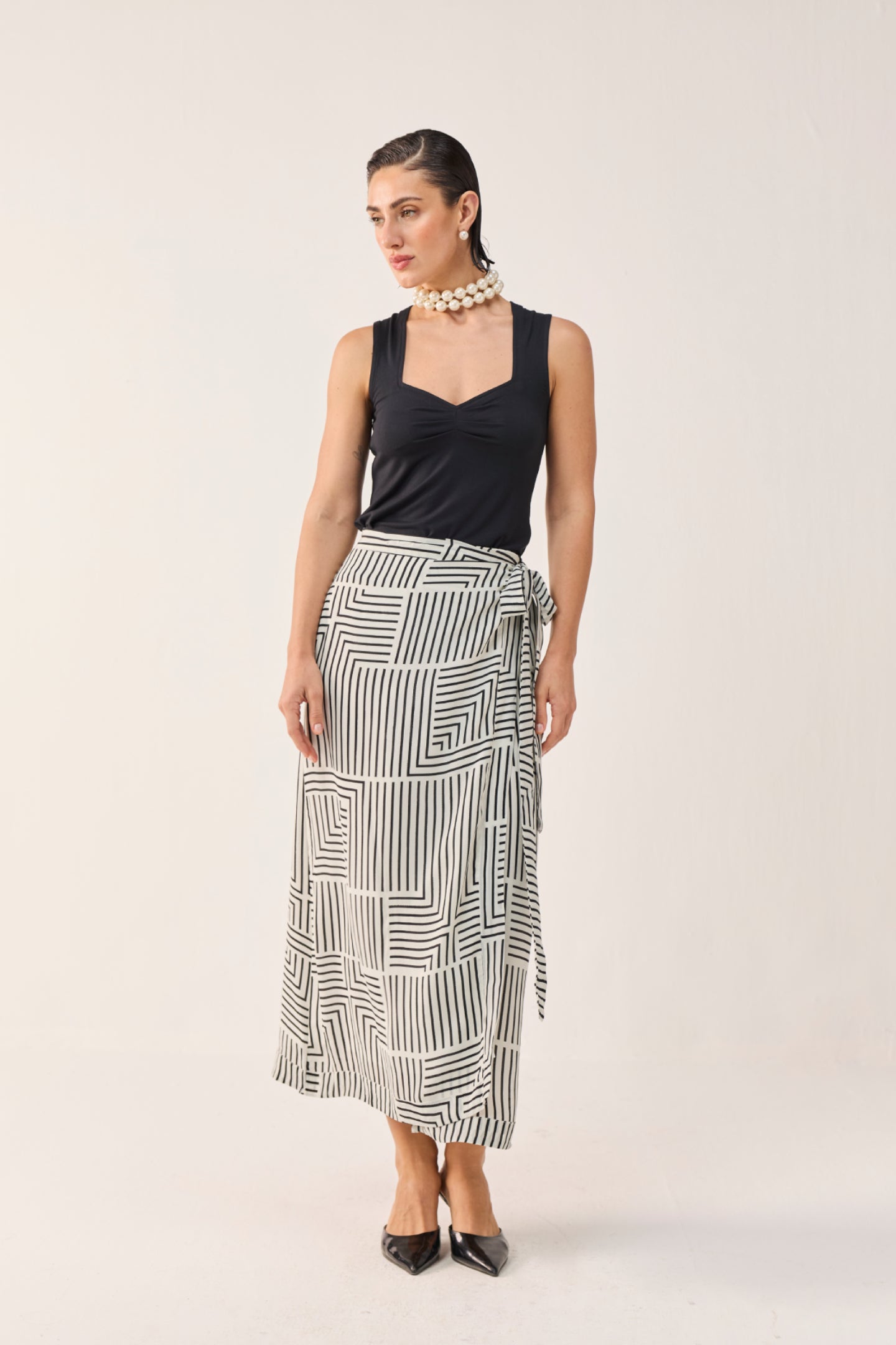 Model wearing Reistor Regular Sweetheart Neck Top in Black with a black and white printed wrap skirt.
