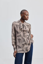 Reistor Relaxed-Fit Top with Front-tie in Animal Print, shown in a full-length view with long sleeves, tie-neck detail, animal print design, and a relaxed silhouette styled with denim.