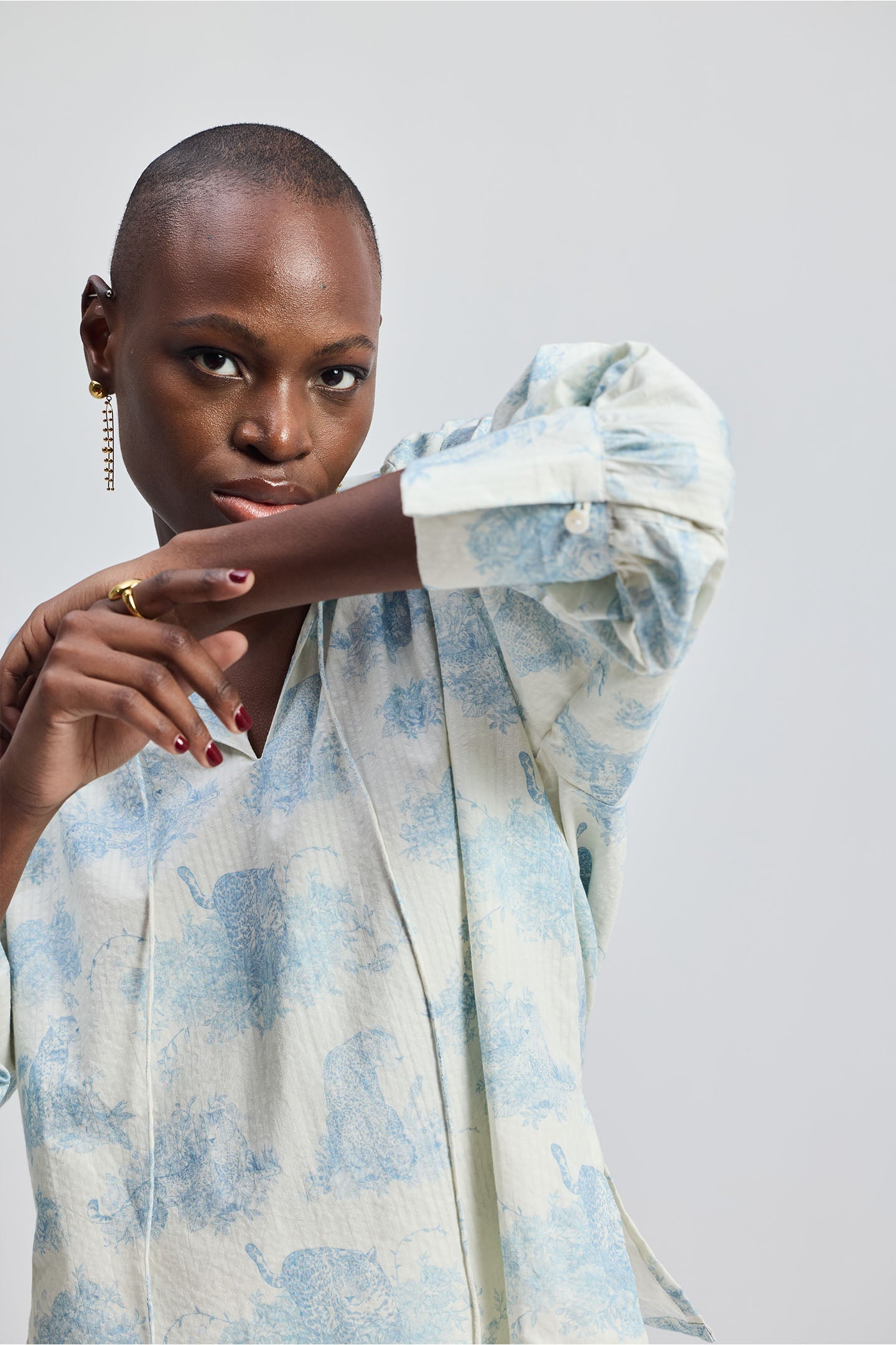 Close-up of a woman wearing the reistor Relaxed-fit Shirt with Drawstring in Animal Print, featuring a soft blue pattern and relaxed sleeves on a clean studio background.