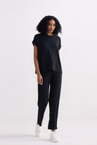 A sleek, full-length profile of the reistor Relaxed Tee Set in Black, featuring a minimalist short-sleeve top and coordinating straight-leg loungewear pants for a polished yet comfortable sustainable look.