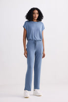 A front-facing studio shot of a model wearing the reistor Relaxed Tee Set in Blue, a sustainable loungewear ensemble featuring a soft, short-sleeved top and matching straight-leg trousers with an adjustable drawstring waist.