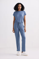 A full-length front view of a model wearing the reistor Relaxed Tee Set in Blue, featuring a soft short-sleeve crew neck top and matching straight-leg drawstring trousers styled with white sneakers.