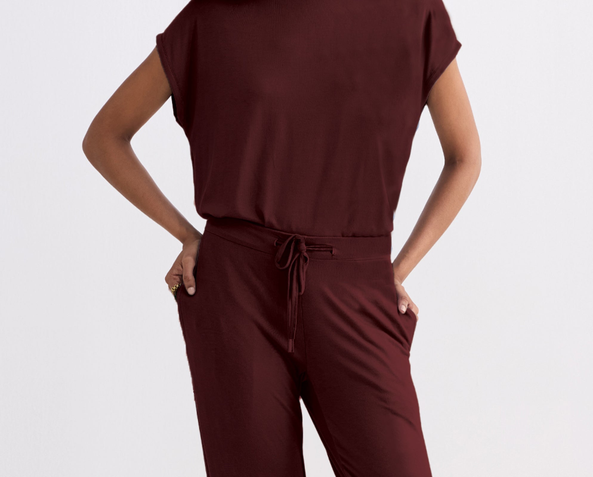 Merlot jumpsuit worn by a person on a light gray background