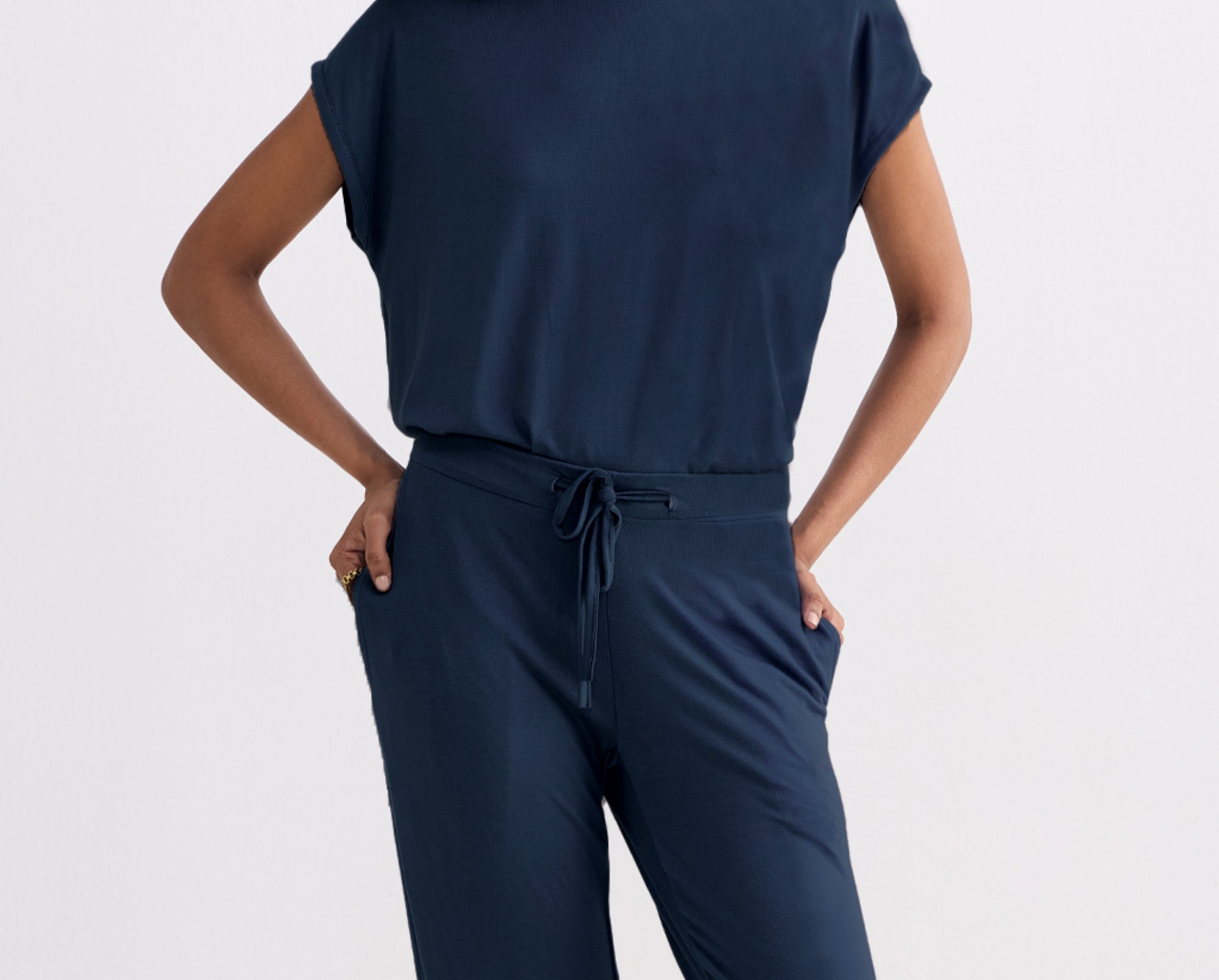 Person wearing a navy blue outfit with a plain background