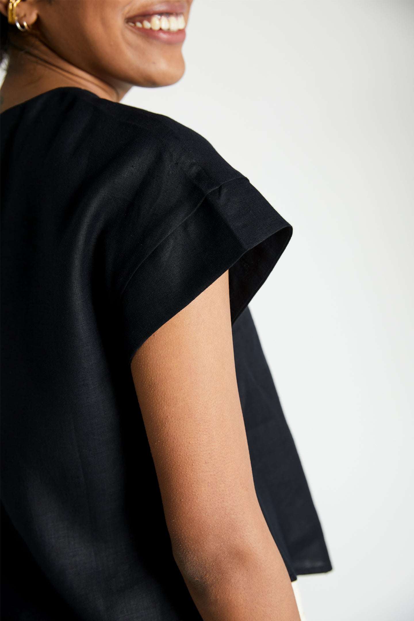 Reistor Sandcastle Saturdays Top in Black featuring cap sleeves, breathable sustainable fabric, relaxed fit, and minimalist everyday women's style.