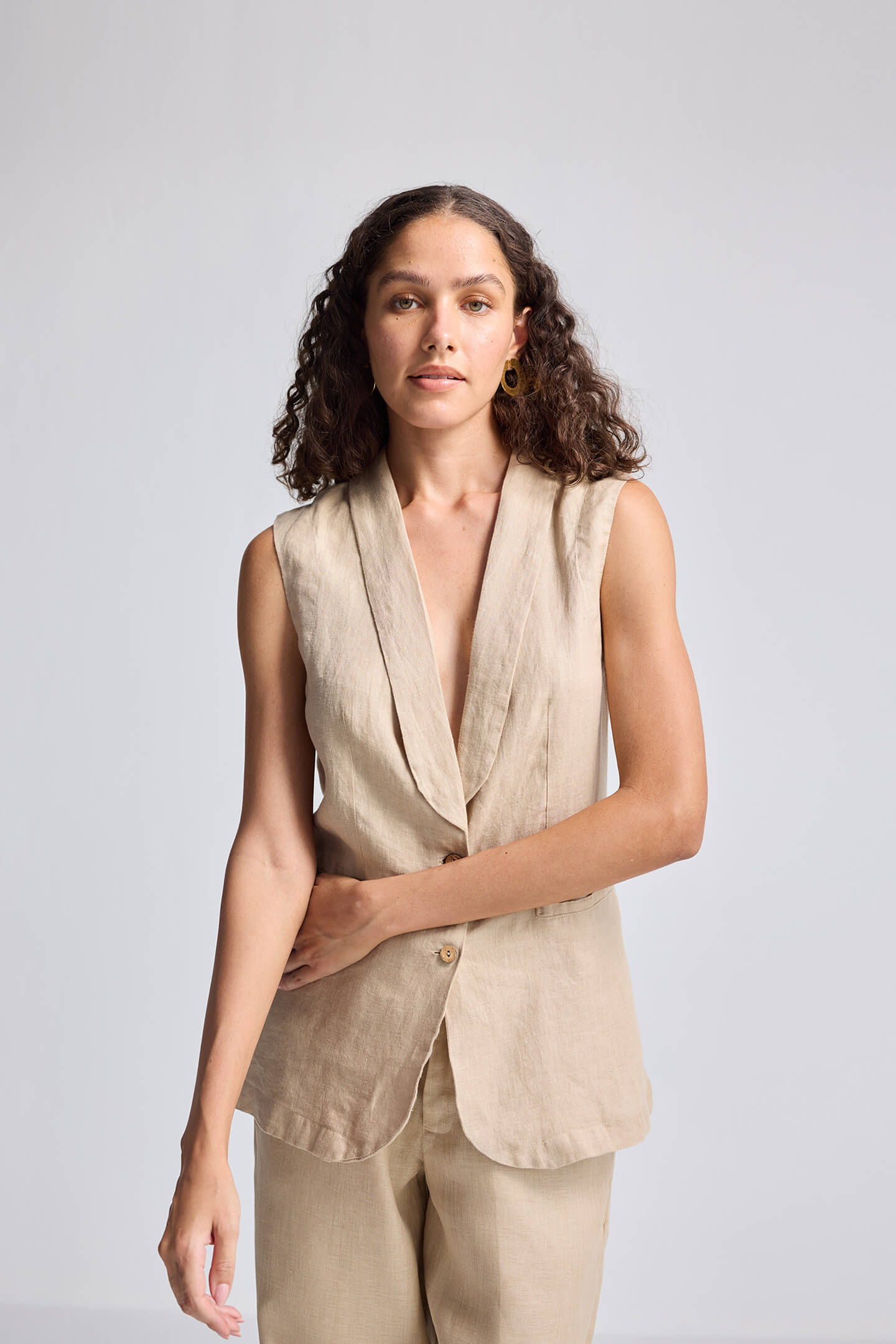 Close-up view of model wearing the Reistor Sleeveless Hemp Jacket in beige, featuring a deep V-neckline, tailored silhouette, and sustainable hemp fabric.