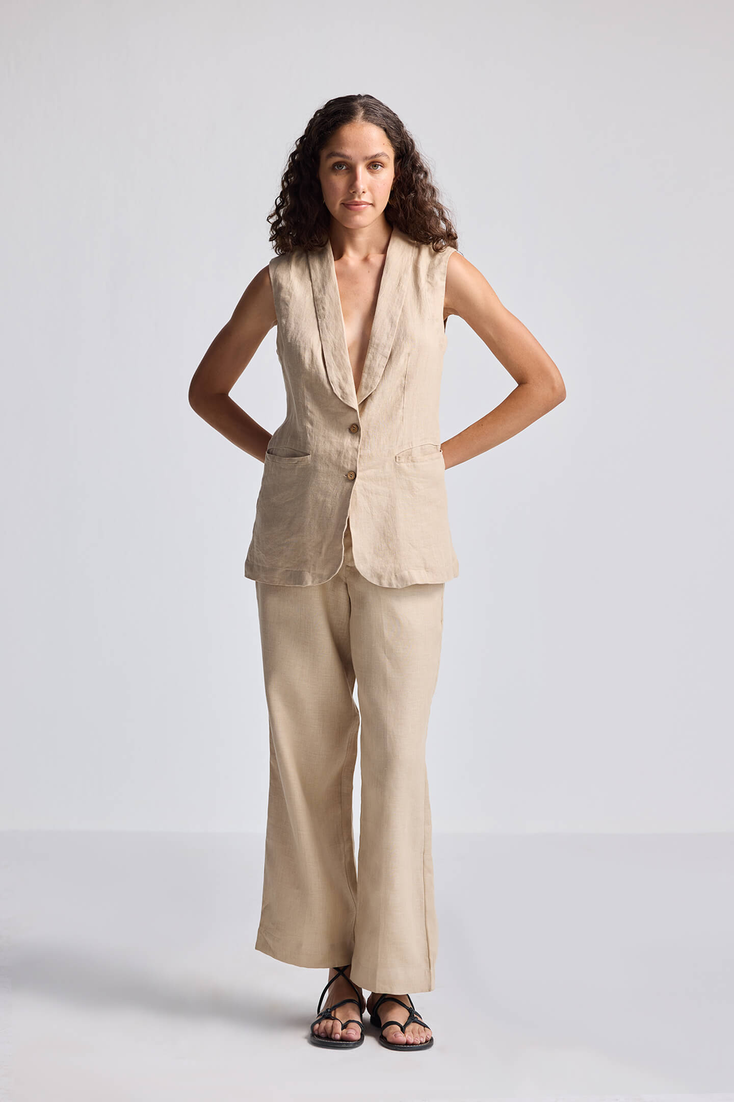 Front view of model wearing the reistor Sleeveless Hemp Jacket in beige, featuring a tailored sleeveless design with button closure, styled with matching hemp pants for a minimalist sustainable look.