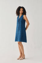 Sleeveless Knee-Length Dress in Blue featuring intricate all-over eyelet embroidery, a V-neckline with self-tie detailing, and a relaxed straight silhouette, shown in a three-quarter side view that highlights its lightweight drape and effortless elegance.