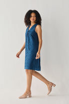 Sleeveless Knee-Length Dress in Blue with eyelet embroidery, a V-neck tie detail, and a relaxed silhouette, shown in motion in a full-length studio view.