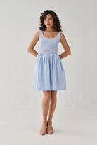 Sleeveless blue stripe mini dress featuring a textured smocked top, flattering fit-and-flare silhouette, and airy design for warm days.