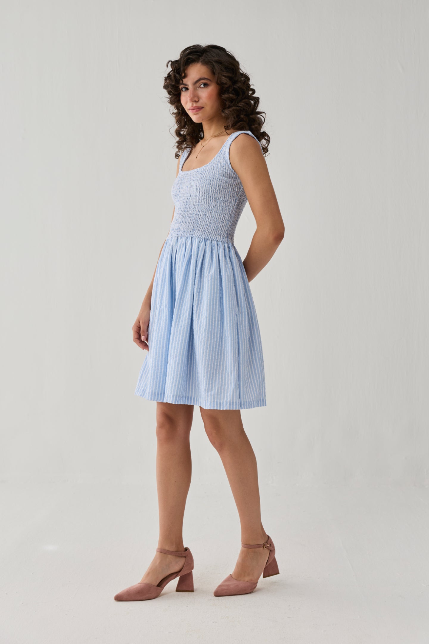 Smocked Short Dress in Blue Stripes showcasing a stretch-smocked upper, graceful drape, and lightweight fabric for a fresh casual outfit.