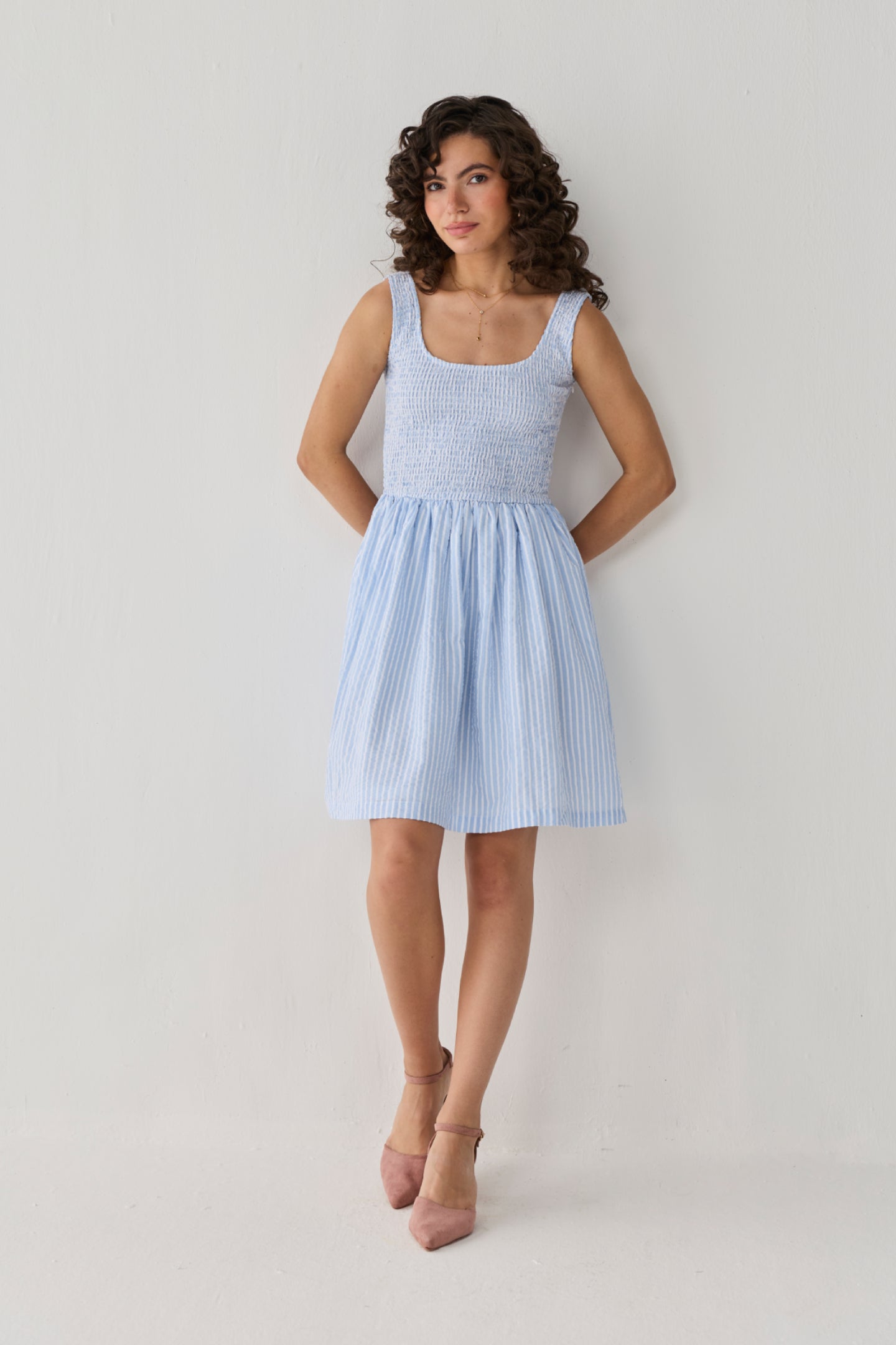 Smocked Short Dress in Blue Stripes crafted with delicate vertical stripes, a stretch-smocked bodice, and a breezy skirt for warm-weather comfort.