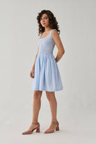 Smocked Short Dress in Blue Stripes designed with intricate smocking, a sleeveless cut, and a flowing skirt that offers comfort and charm.