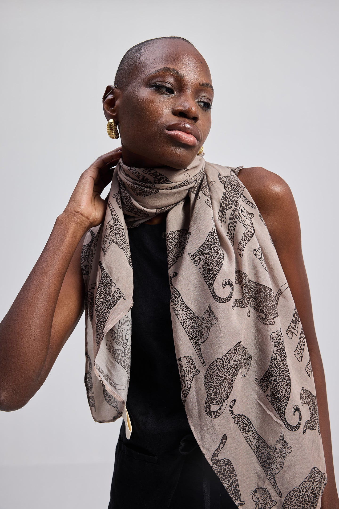 The Mara Scarf in Brown draped on model with leopard print pattern