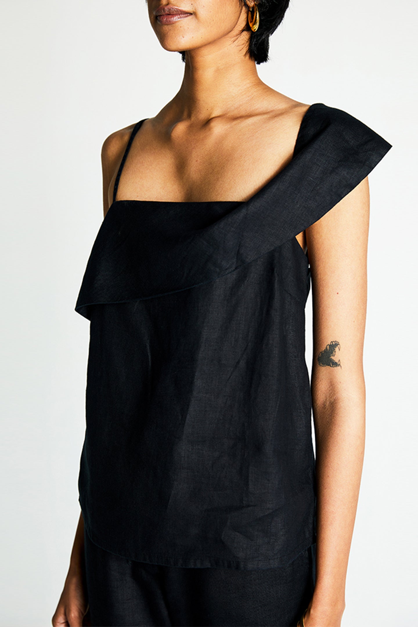 Reistor The Wandering Wave Top in Black featuring an asymmetric neckline, sustainable breathable fabric, relaxed fit, and modern women's everyday style.