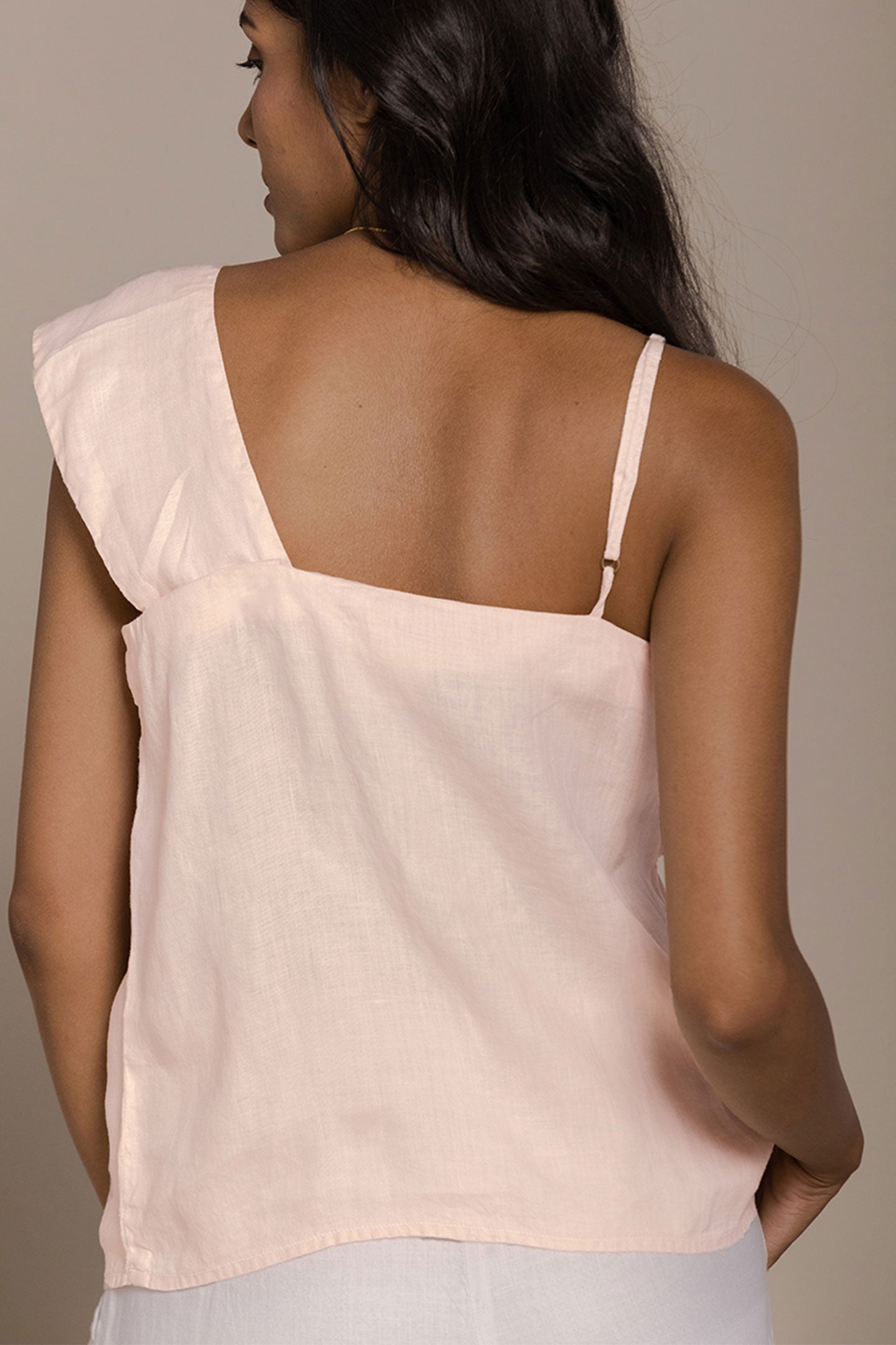 Reistor The Wandering Wave Top in Ice Pink features an elegant back view with an asymmetrical silhouette and airy drape.