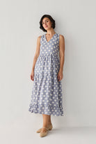 Blue Polka Tiered Midi Dress with a flowing three-tier skirt and flattering V-neckline, styled in a graceful pose that highlights its drape.