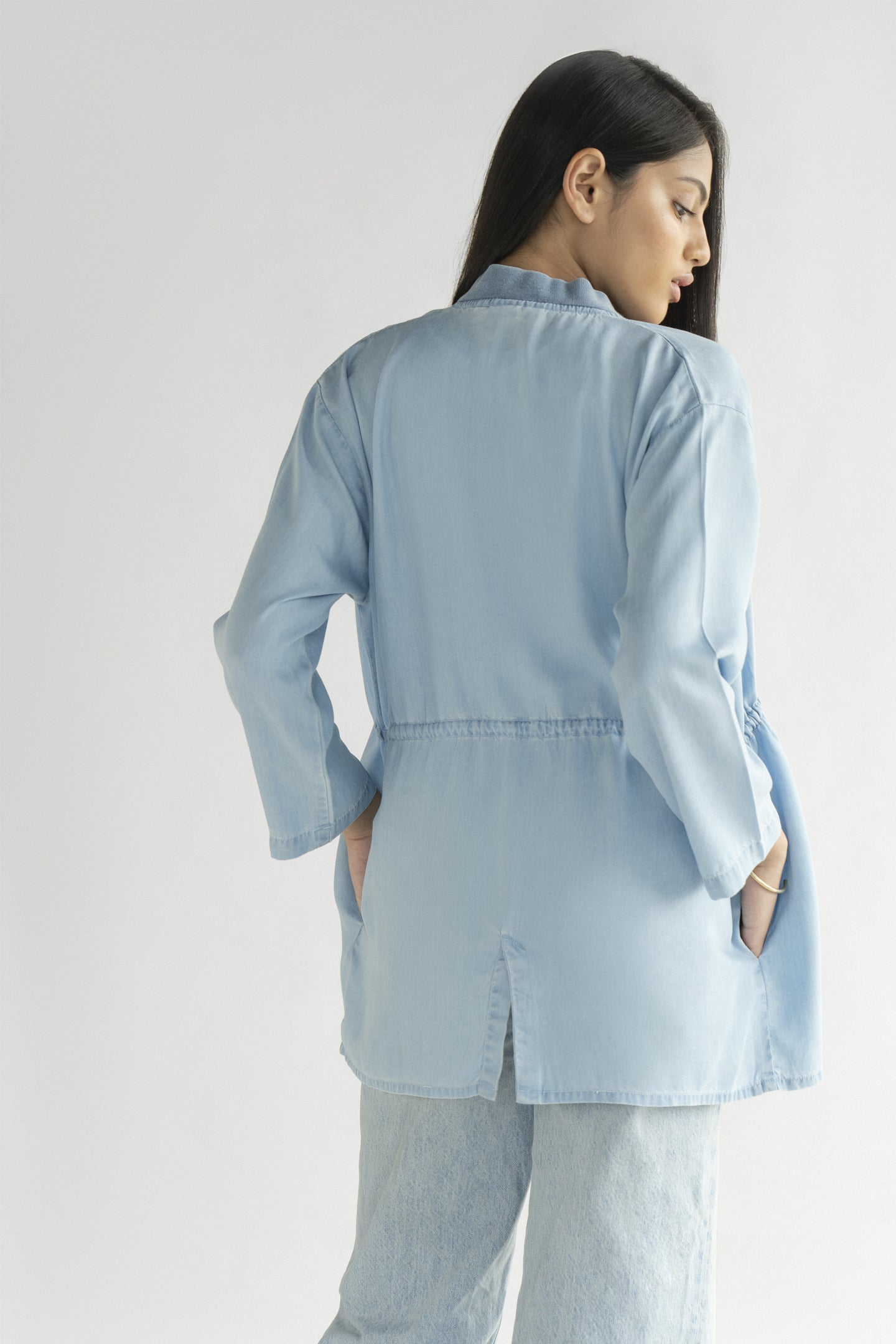 Woman wearing a light blue shirt against a white background