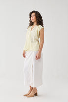 Reistor V-neck Overlap Top in Butter Lemon worn with a white midi skirt and block heels, shown in a side profile with a relaxed fit.