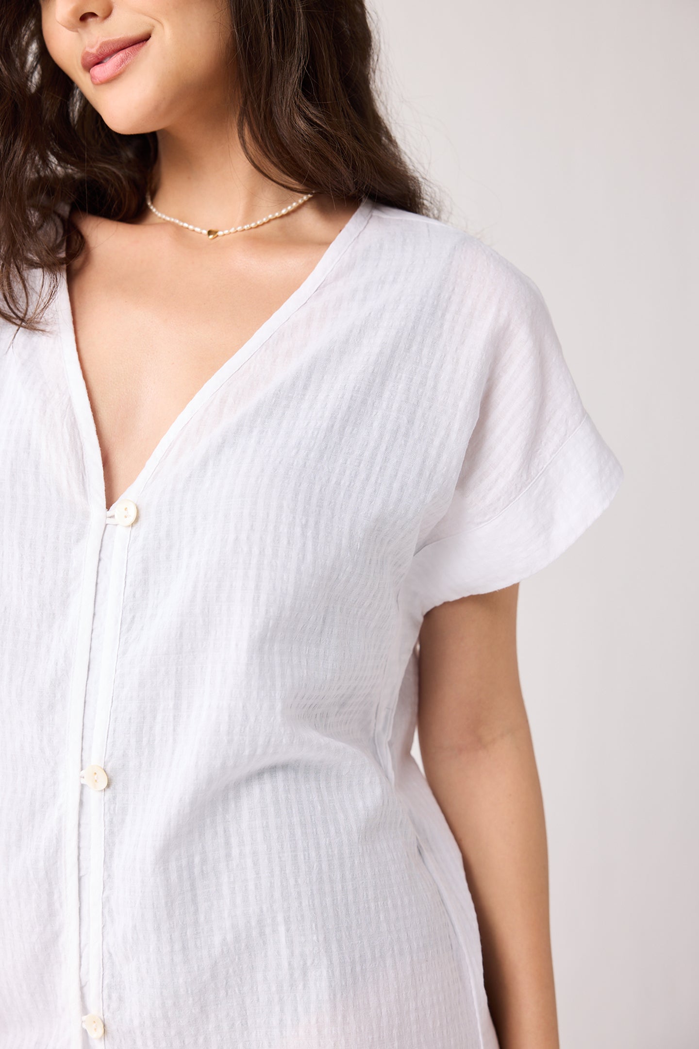 Woman wearing a white dress with a plain background