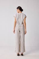 Back view of Wide-leg Drawstring Pants in Stripes by Reistor, showcasing a relaxed wide-leg fit, vertical striped pattern, and lightweight flowy fabric worn by a model.