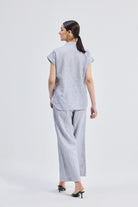 Model wearing grey striped Wide Leg Linen Pants by reistor with a matching linen shirt for a sustainable summer look.