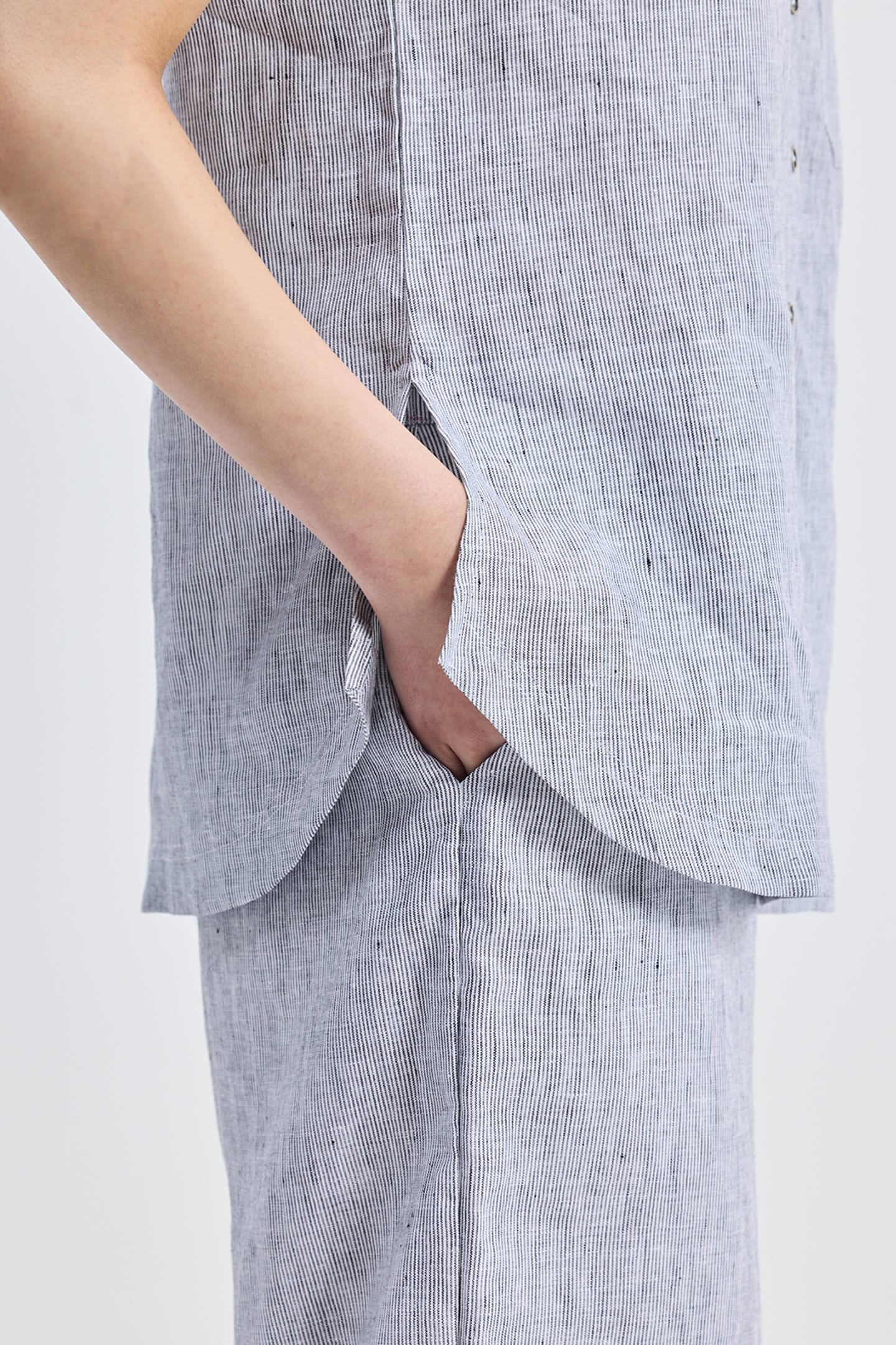 Model wearing grey Wide Leg Linen Pants by reistor with a matching striped linen shirt set.