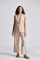 Model wearing reistor Wide Leg Pants in Hemp, featuring a relaxed wide-leg fit, natural beige color, and breathable sustainable fabric, styled with a sleeveless matching vest.