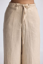 Close-up of Reistor Wide Leg Pants in Hemp, highlighting the soft textured hemp fabric, adjustable drawstring waist, and relaxed sustainable design in a natural beige shade.