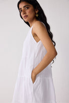Woman wearing a white dress against a plain background