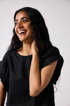 Woman wearing a black top against a white background
