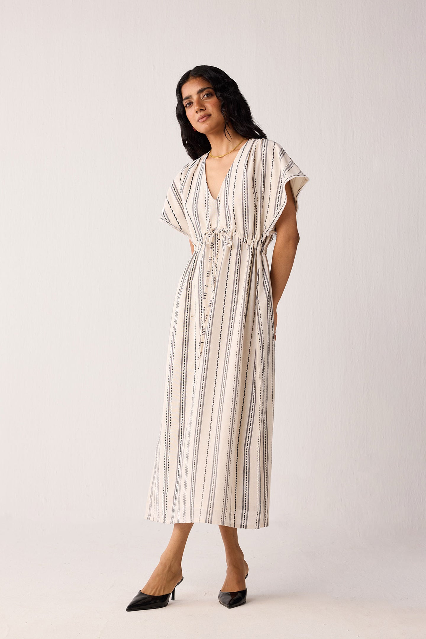 Woman wearing a striped dress against a white background