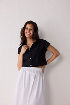 Woman wearing a black top against a plain background