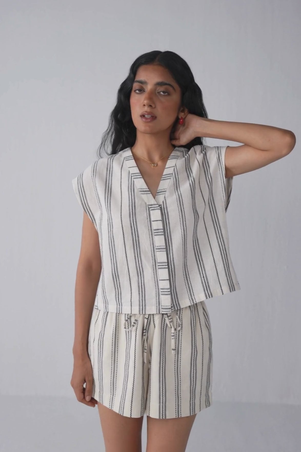 Video of a model in Reistor Regular Drawstring Shorts in Stripes, featuring full-body poses, playful twirls, and smooth fabric flow. Detailed close-ups highlight the striped pattern, soft fabric, adjustable drawstring waistband, and relaxed, comfortable fit for versatile styling.