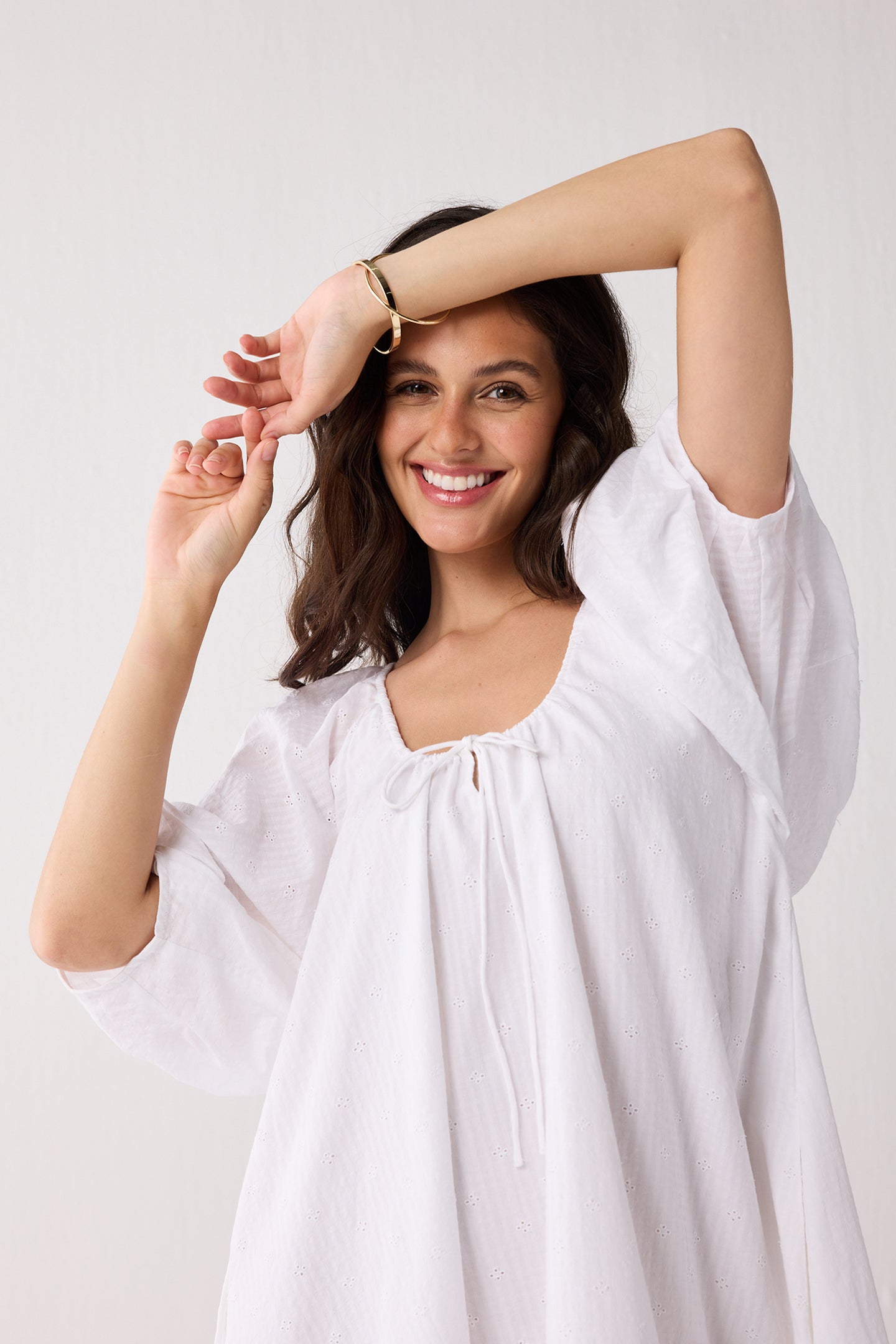 Woman wearing a white blouse against a plain background
