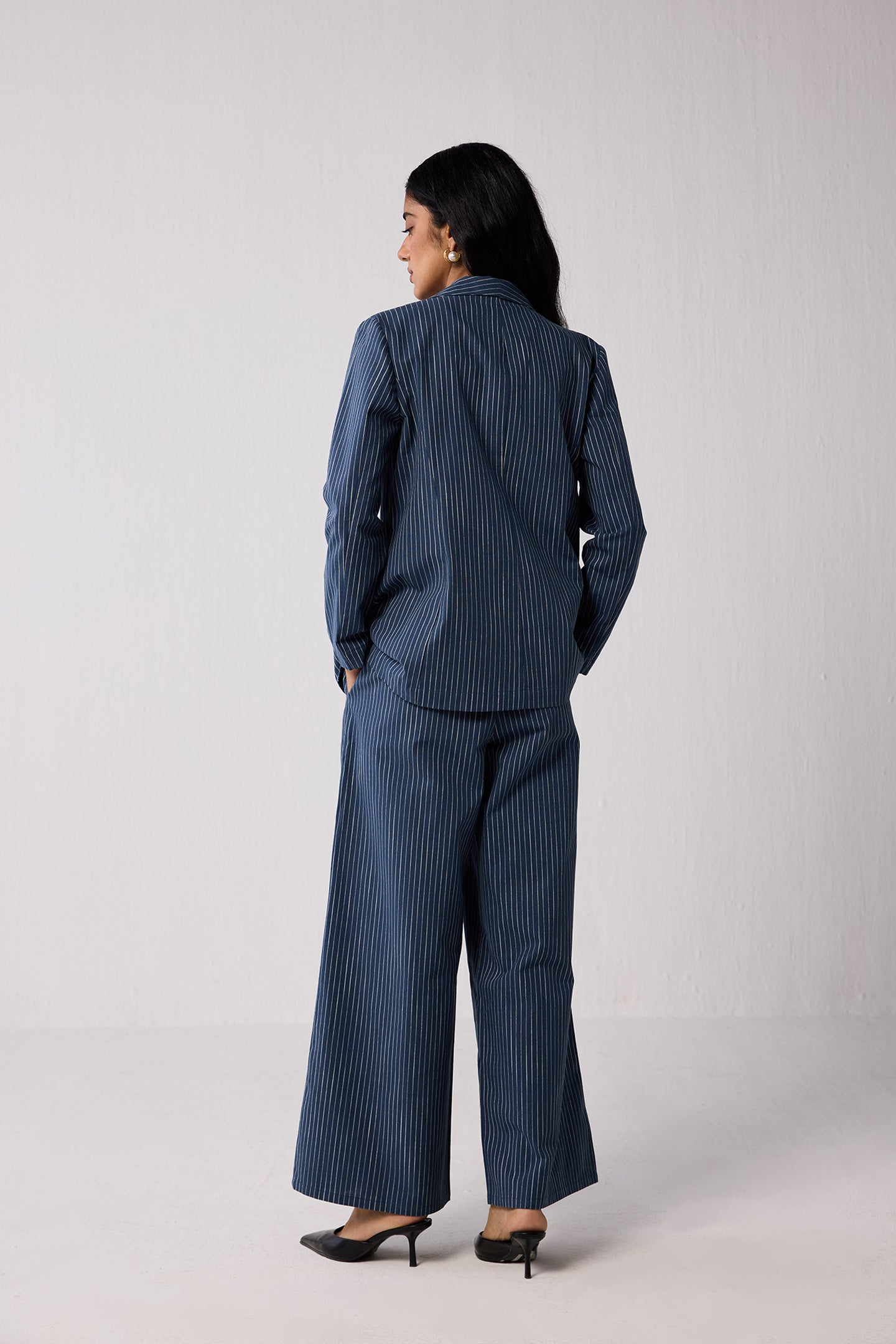 Woman wearing a blue pinstripe suit  on a light background