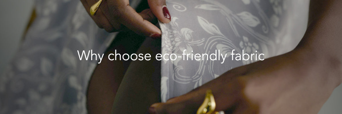 Person holding fabric with text 'Why choose eco-friendly fabric' on a blurred background