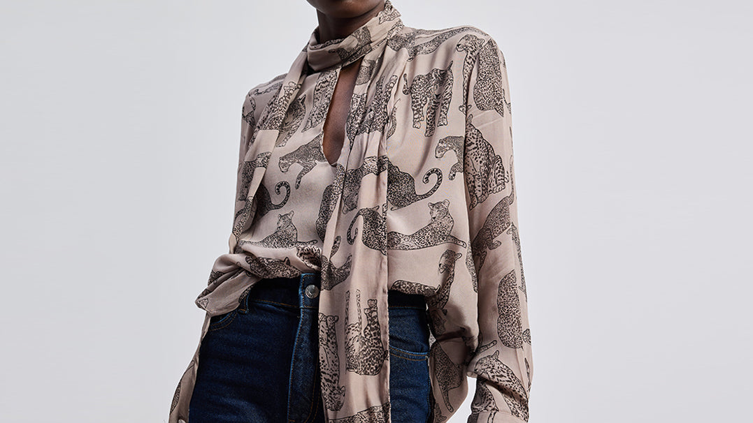 Person wearing a patterned scarf with a neutral background