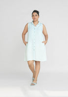Reistor Dreaming of Blue Skies Dress, sleeveless button-front shirt dress in soft blue with side pockets, a relaxed sustainable women's summer dress.