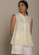 yellow sleeveless collared top with a hidden placket lends a sleek look to this classic top.