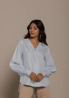 blue vintage shirt with an overlapped collar and balloon sleeves with buttoned wrists