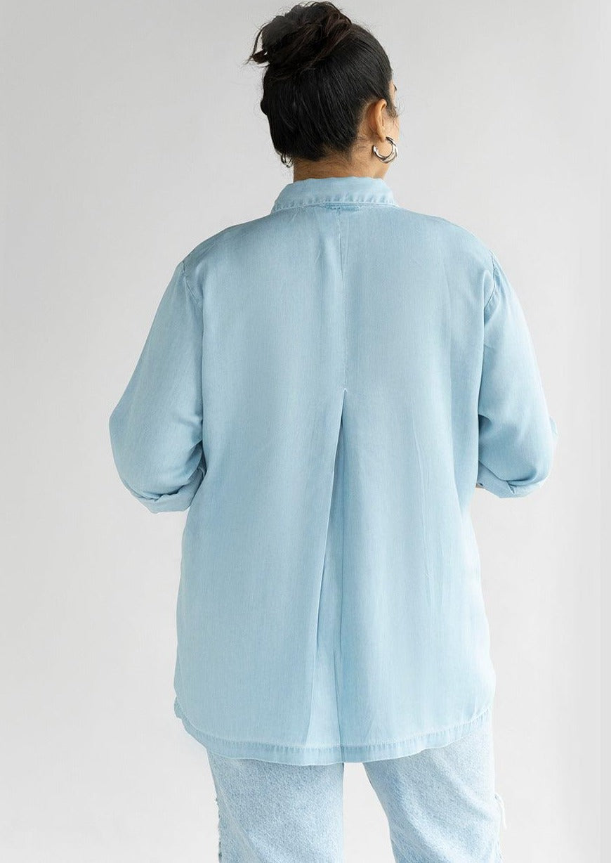 Rear view of the Reistor Ready for the World Shirt in Blue Denim, crafted from soft lightweight denim with a back pleat and timeless casual style.