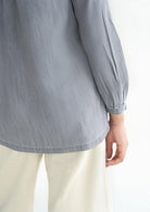 Reistor Shades of Everyday Top in Stone Grey showcasing the back hem and sleeve detail, crafted from breathable lightweight fabric for lasting comfort.